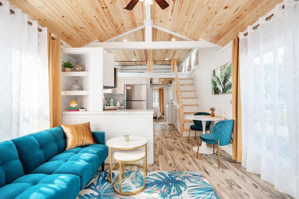 een woonkamer met een blauwe bank en een keuken bij 7 Le Soleil Retro Tiny House, Boat Parking, Mins to Lake Guntersville, City Harbor in Guntersville