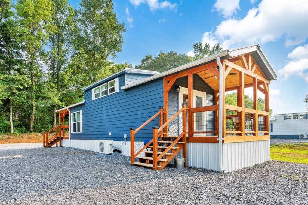 ein kleines blaues Haus mit einer Veranda in der Unterkunft 8 All Decked Out, Luxury Tiny House, Boat Parking Mins to Lake Guntersville, Downtown in Guntersville