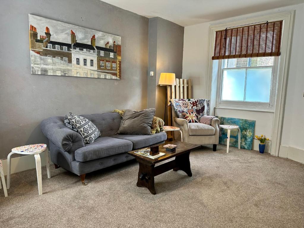 a living room with a couch and a chair at Flat Near Richmond Upon Thames in Richmond