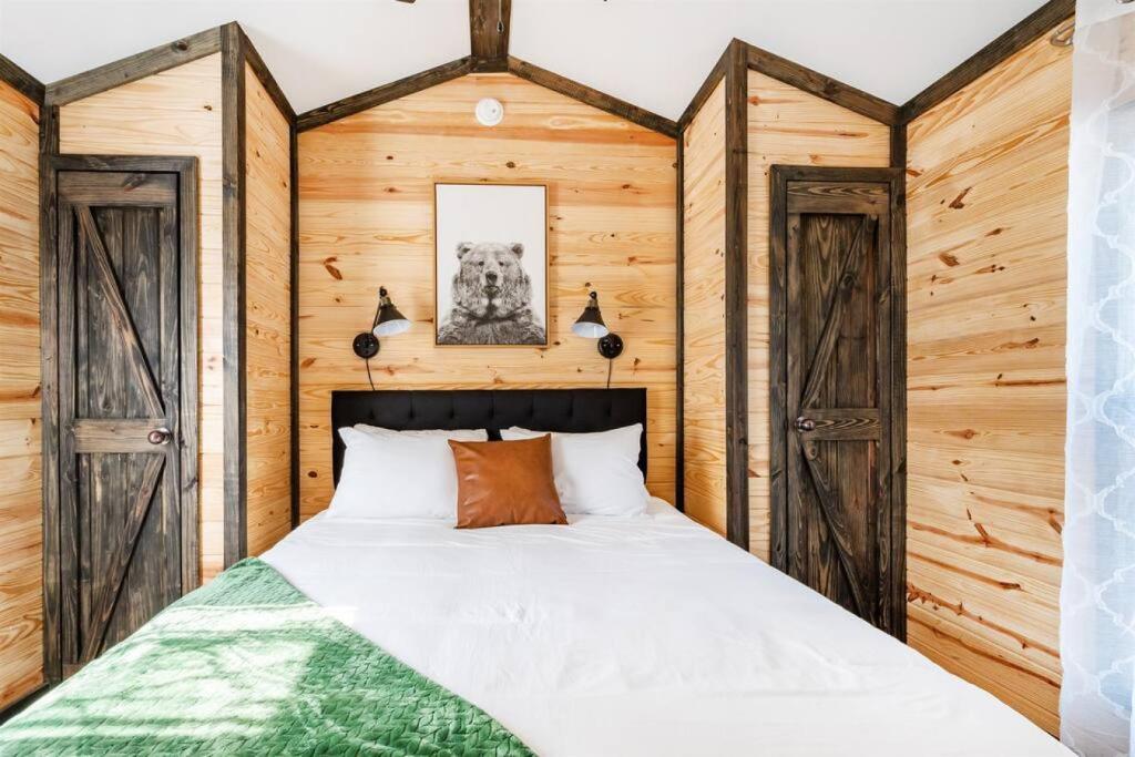 - une chambre avec un lit et des murs en bois dans l'établissement 3 Bearly Working Luxury Tiny House Firepit Mins to Lake Guntersville, à Guntersville