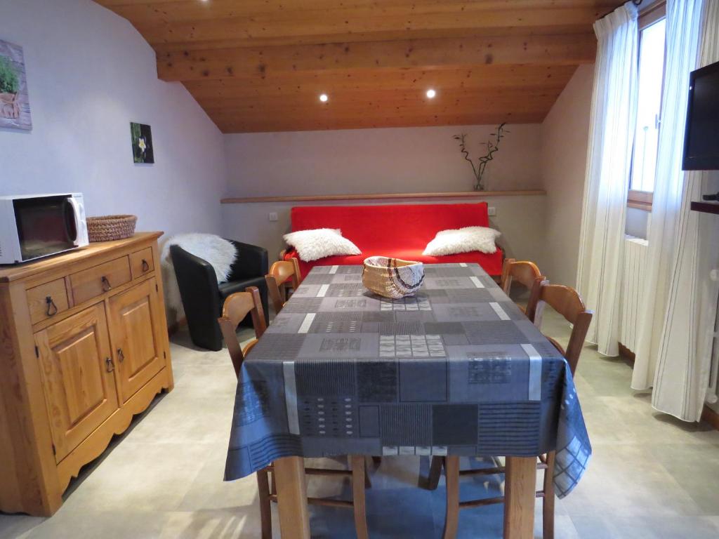 a dining room with a table and chairs and a couch at Appartement Le Grand-Bornand, 2 pièces, 4 personnes - FR-1-467-75 in Le Grand-Bornand