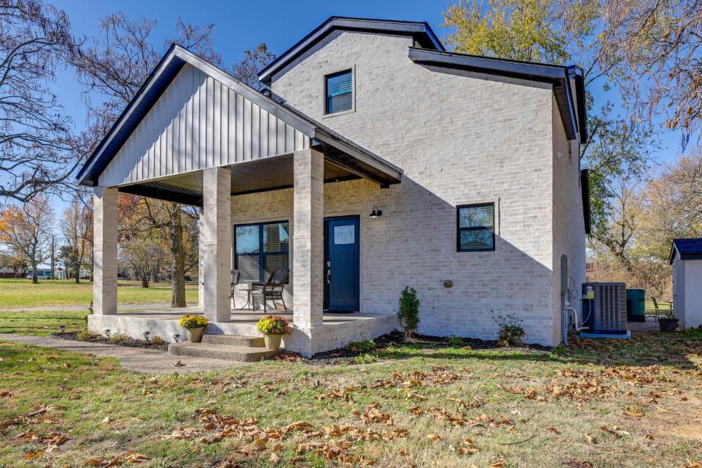 uma casa de tijolos brancos com uma porta azul em Modern Springdale Home 13 Mi to Fayetteville! em Springdale