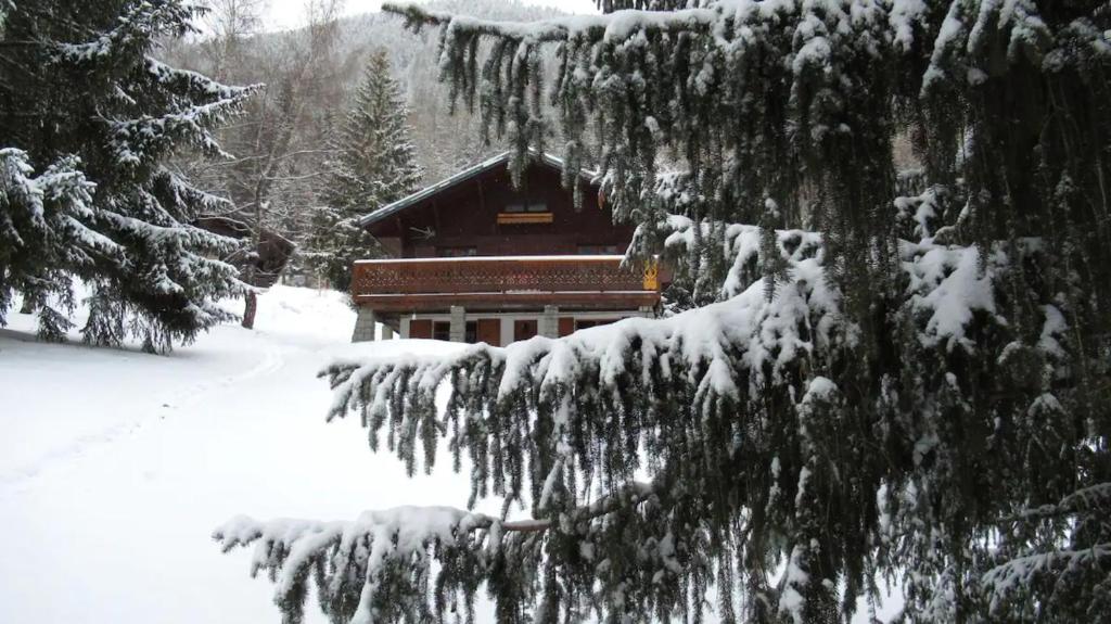 una cabina nel bosco con alberi innevati di Grand Chalet au pays du Mont Blanc a Vallorcine