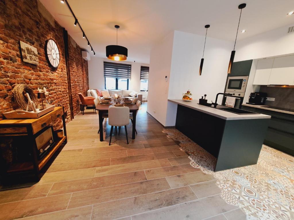 eine Küche und ein Esszimmer mit einem Tisch und einer Theke in der Unterkunft Un gîte sous roche in La-Roche-en-Ardenne