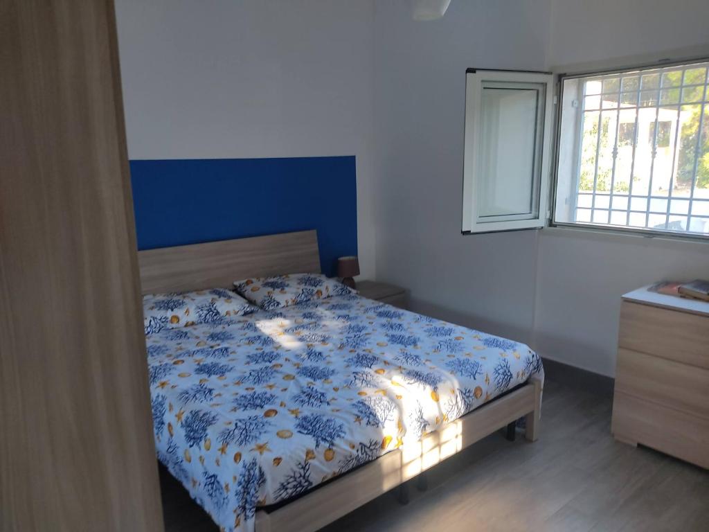 - une chambre avec un lit et une couette bleue et blanche dans l'établissement Villa Sole, à Maruggio
