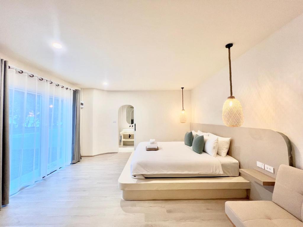 ラヨーンにあるSunvada Beach Rayongの白いベッドルーム(ベッド1台、ソファ付)
