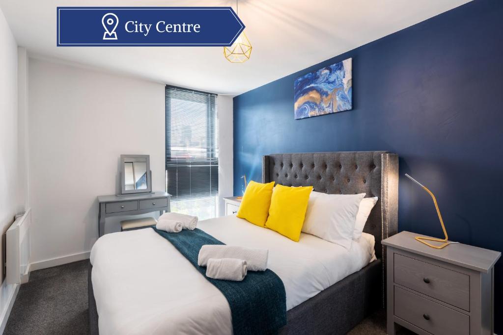 a bedroom with a large bed with a blue wall at Lovely 2BR Apt in Sheffield City Centre in Sheffield