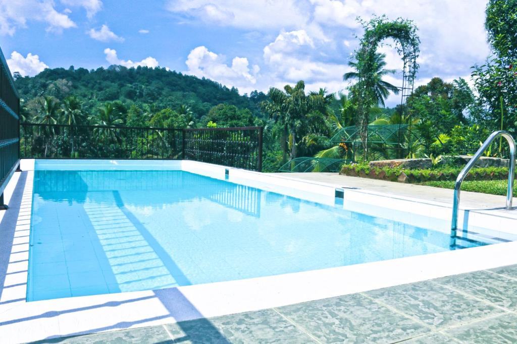 una gran piscina en un patio con árboles en Muduna Walawwa Resort, en Kandy