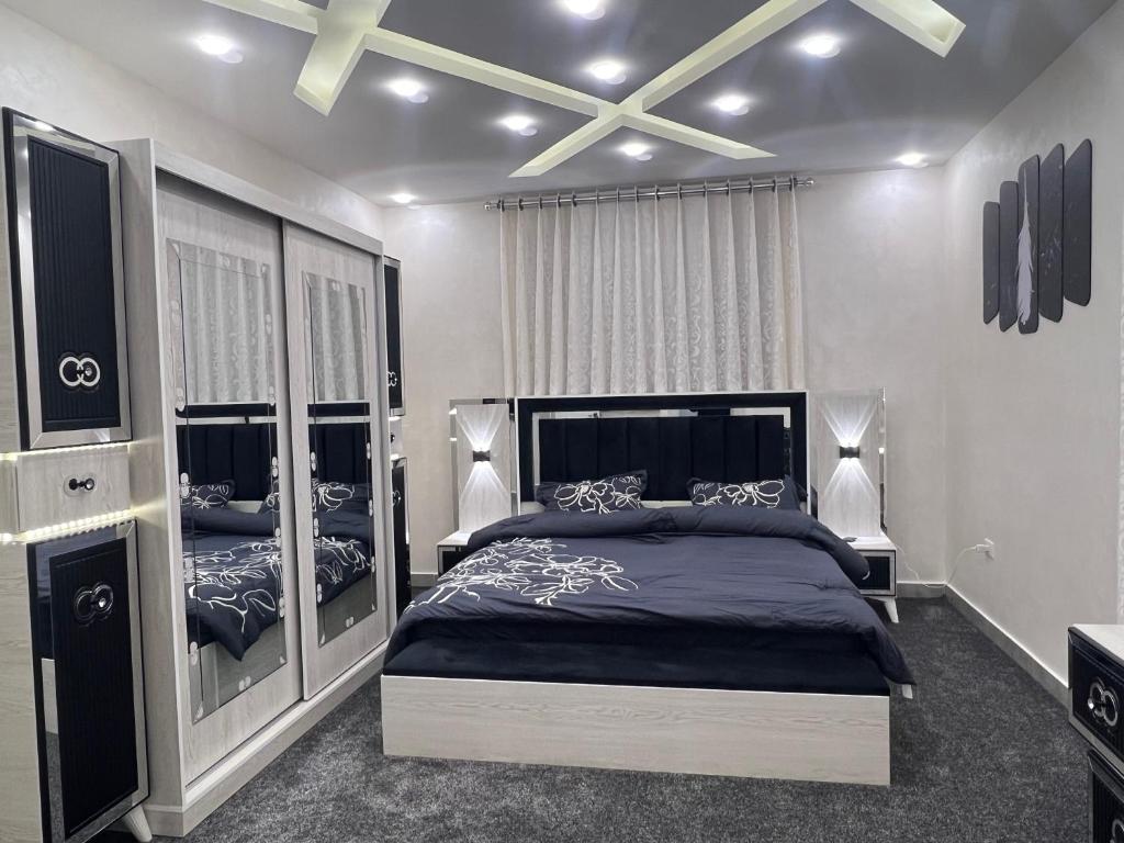 a bedroom with a large bed and two mirrors at Asia Hotel Apartments in Irbid