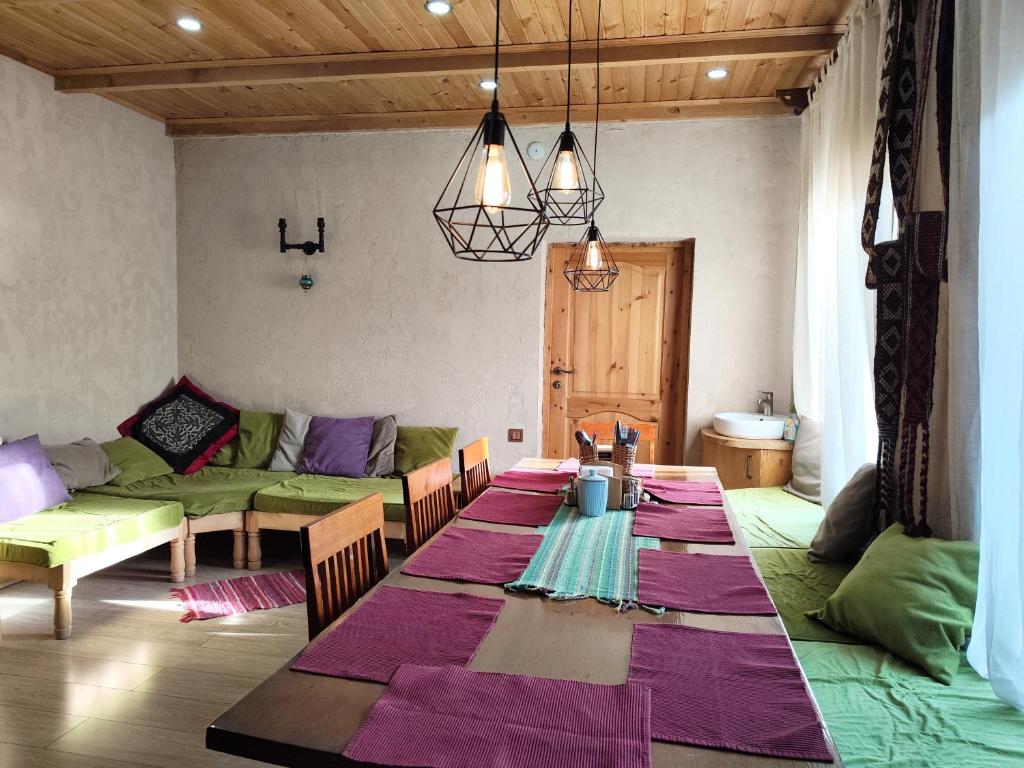 a living room with a table and a couch at Evergreen Guesthouse in Karakol