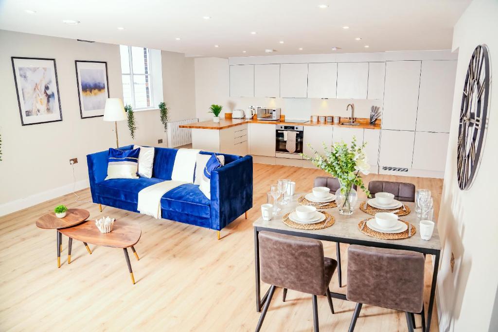 a living room with a blue couch and a table at Shrewsbury apartments by BEVOLVE - Free Parking in Shrewsbury