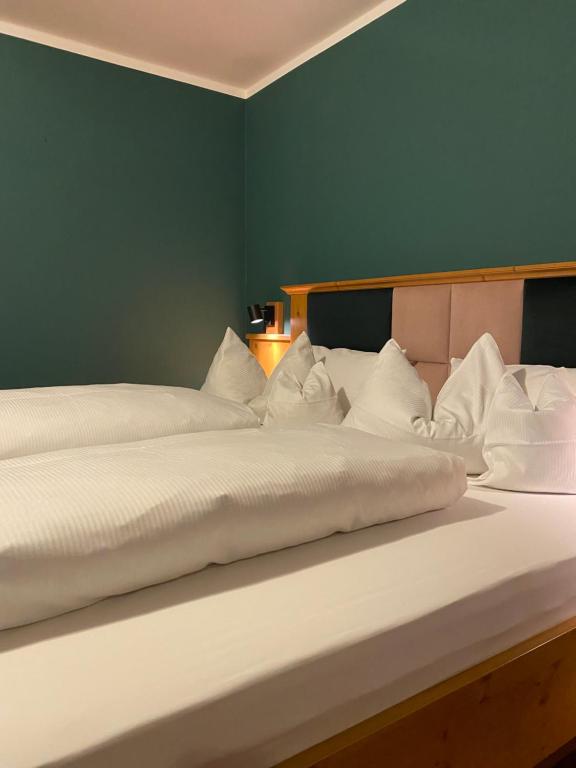 2 Betten in einem Zimmer mit grüner Wand in der Unterkunft Beim Has’n in Rimsting