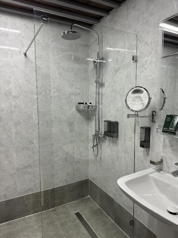 a bathroom with a glass shower and a sink at Mir Luxe Plaza in Tashkent