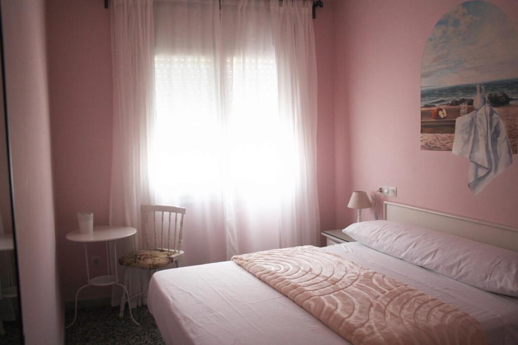 1 dormitorio con cama blanca y ventana en Hostal Isabel II, en Figueres