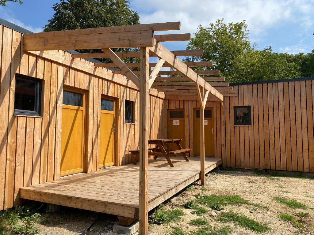 eine Holzhütte mit einem Picknicktisch auf dem Deck in der Unterkunft Camping la Faloise 