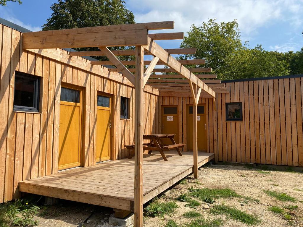 Cabaña de madera con mesa de picnic en la terraza en Camping la Faloise, en Angicourt