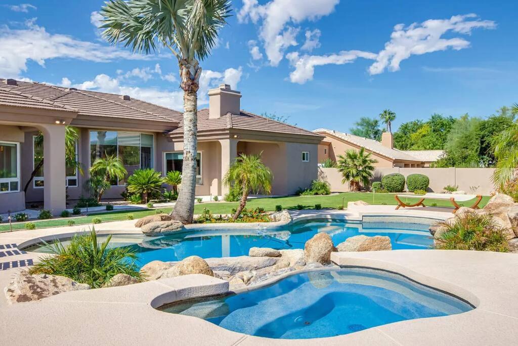 ein Haus mit einem Pool und einer Palme in der Unterkunft 5 bd Luxury Oasis Heated Pool Spa Pickle Ball in Scottsdale