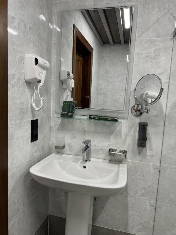 a bathroom with a white sink and a mirror at Mir Luxe Plaza in Tashkent