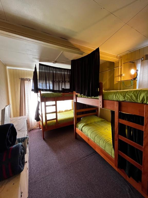 two bunk beds in a room with a window at La Minga Hostel in Castro