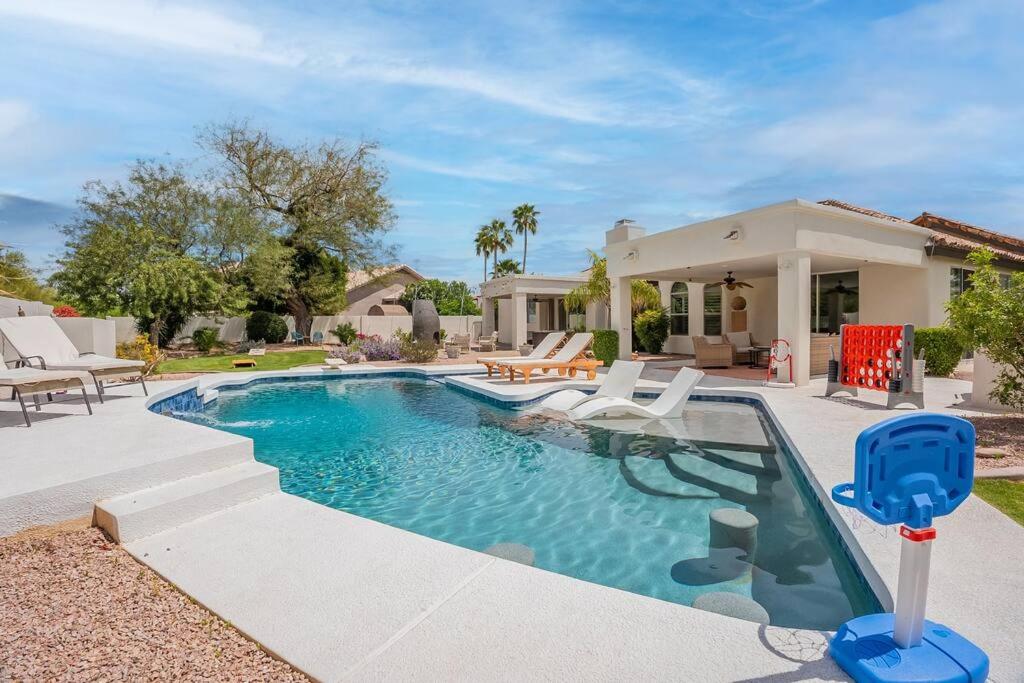 a swimming pool with chairs and a house at Stunning 5 Bed Luxury Oasis Heated Pool Hot Tub in Scottsdale