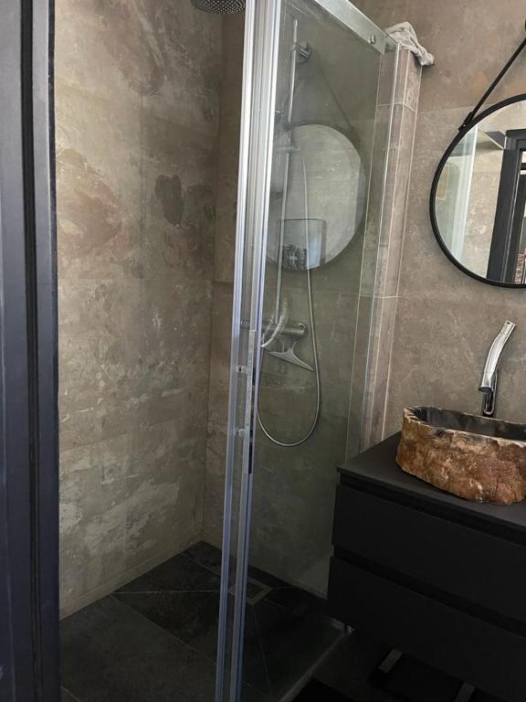 a shower with a glass door next to a sink at Appartement vue Tour Eiffel paris 16 Eme in Paris