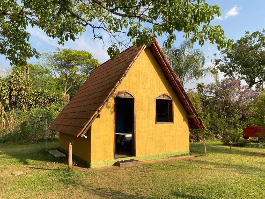 a small yellow house with a brown roof at Pousada da Maria Alair belo vale mg in Belo Vale