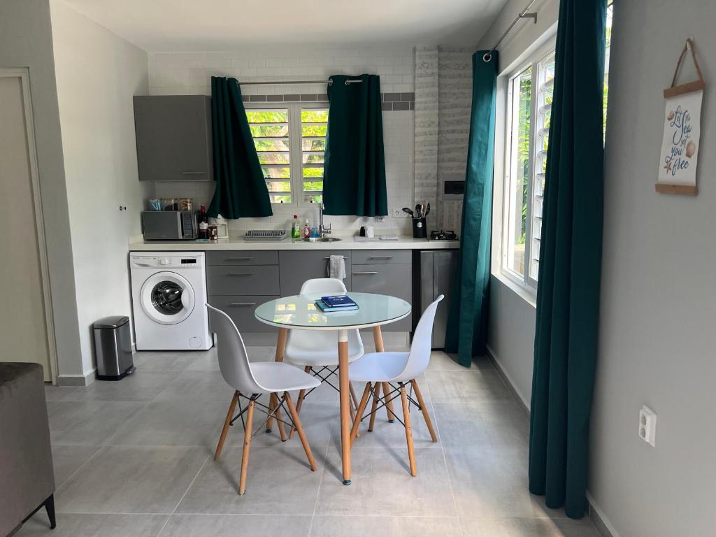 a kitchen with a table and chairs in a kitchen at Tropical Escape: Spanish Water Studio Curacao in Willemstad