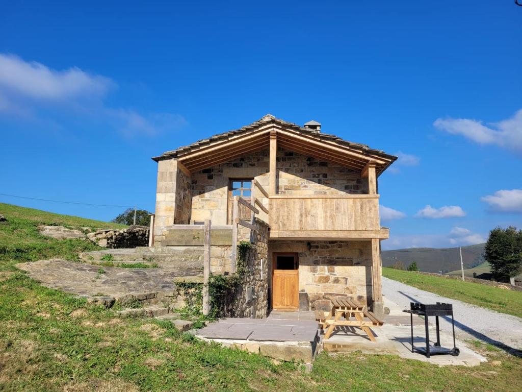 - un petit bâtiment avec une porte en bois sur une colline dans l'établissement Cabaña Pasiega Montes del Pas, 