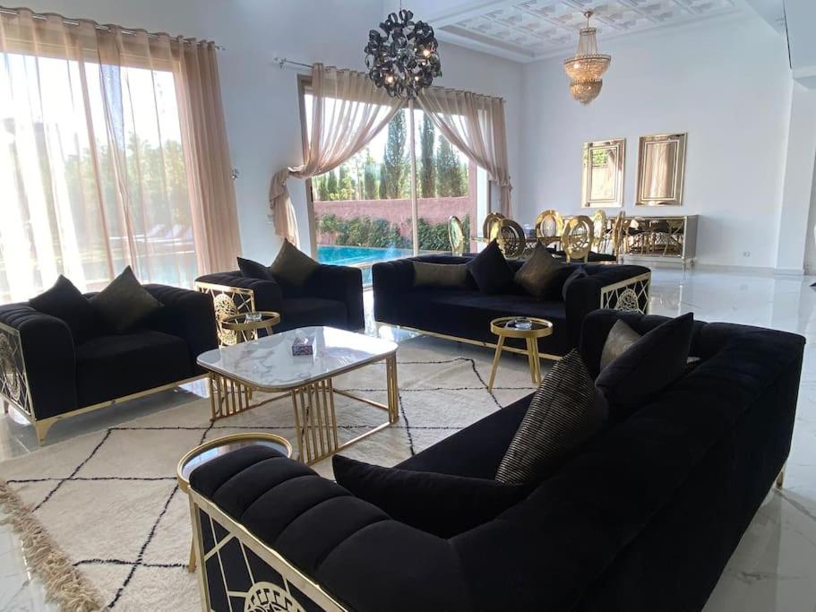 ein Wohnzimmer mit schwarzen Sofas und einem Tisch in der Unterkunft Villa Valentina in Marrakesch