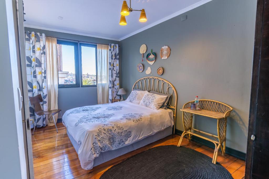 a small bedroom with a bed and a table at Val Paradou - ex - Casa Magnolia in Valparaíso