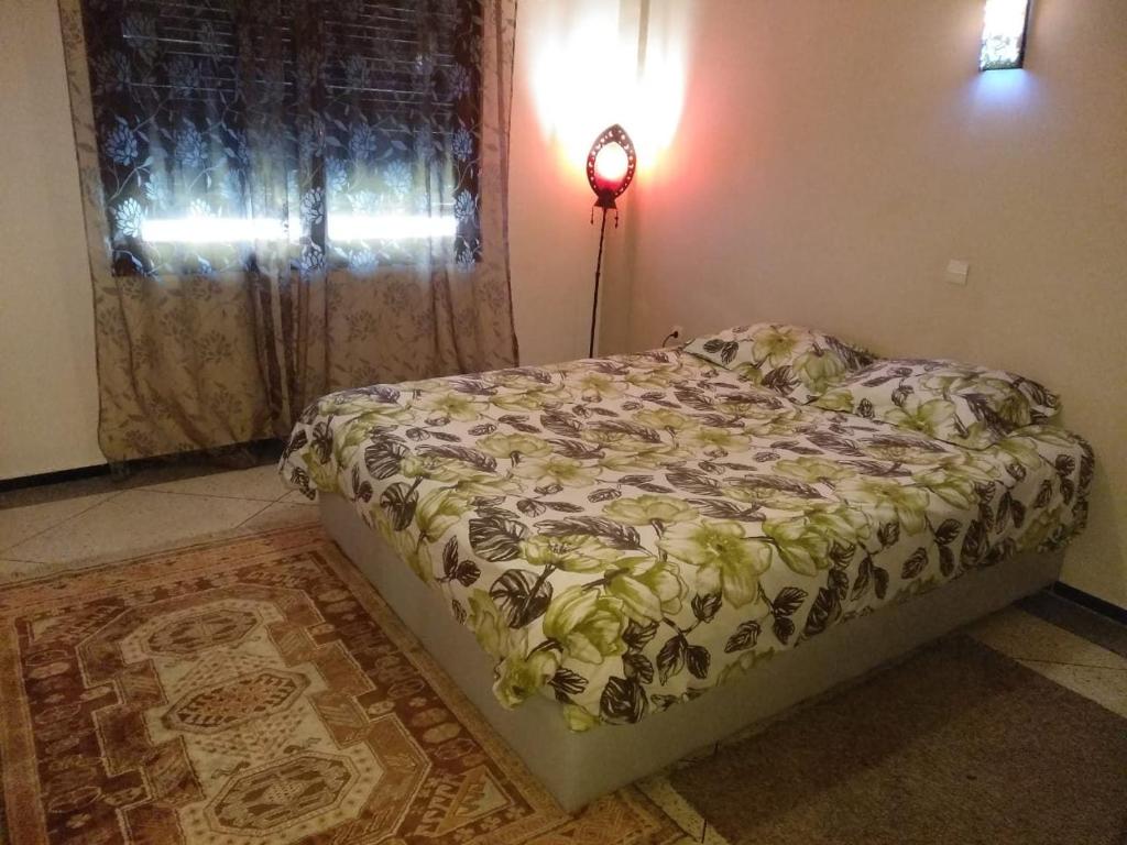 1 dormitorio con cama, ventana y lámpara en Central Appartement Hamria Meknes, en Meknès