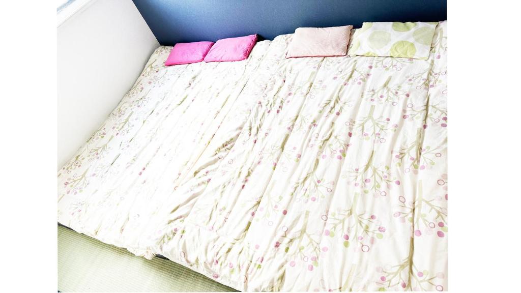 Una cama con dos almohadas rosas encima. en Fukushige Building - Vacation STAY 15723, en Tokio