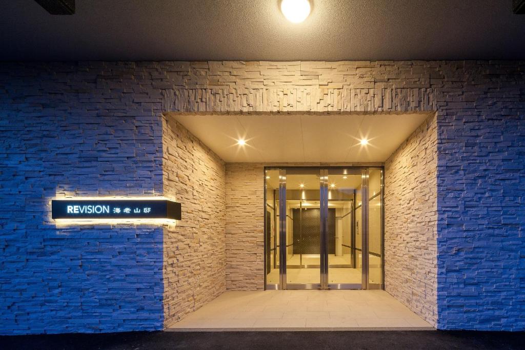 una entrada a un edificio con una pared de ladrillo azul en REVISION Kairouyama-tei - Vacation STAY 15800, en Hiroshima