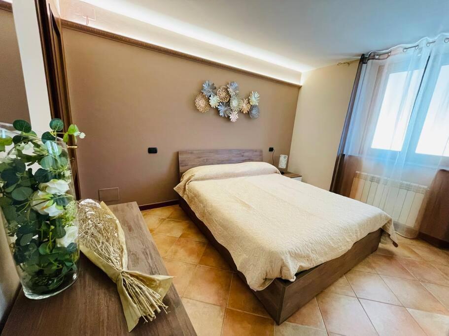 a bedroom with a bed and a vase of flowers at La maison de Daniela in Settimo Vittone