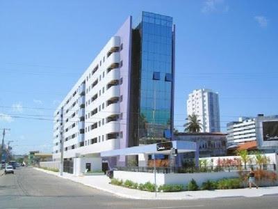 un gran edificio al lado de una calle de la ciudad en Pajucara Flat, en Maceió