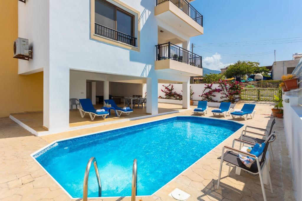 une villa avec piscine et mobilier de jardin dans l'établissement Villa Serena, à Pomos