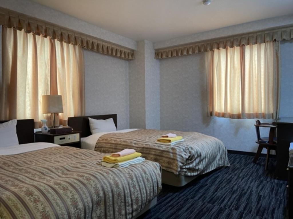 a hotel room with two beds with towels on them at Business Green Hotel Hino - Vacation STAY 16322v in Hino