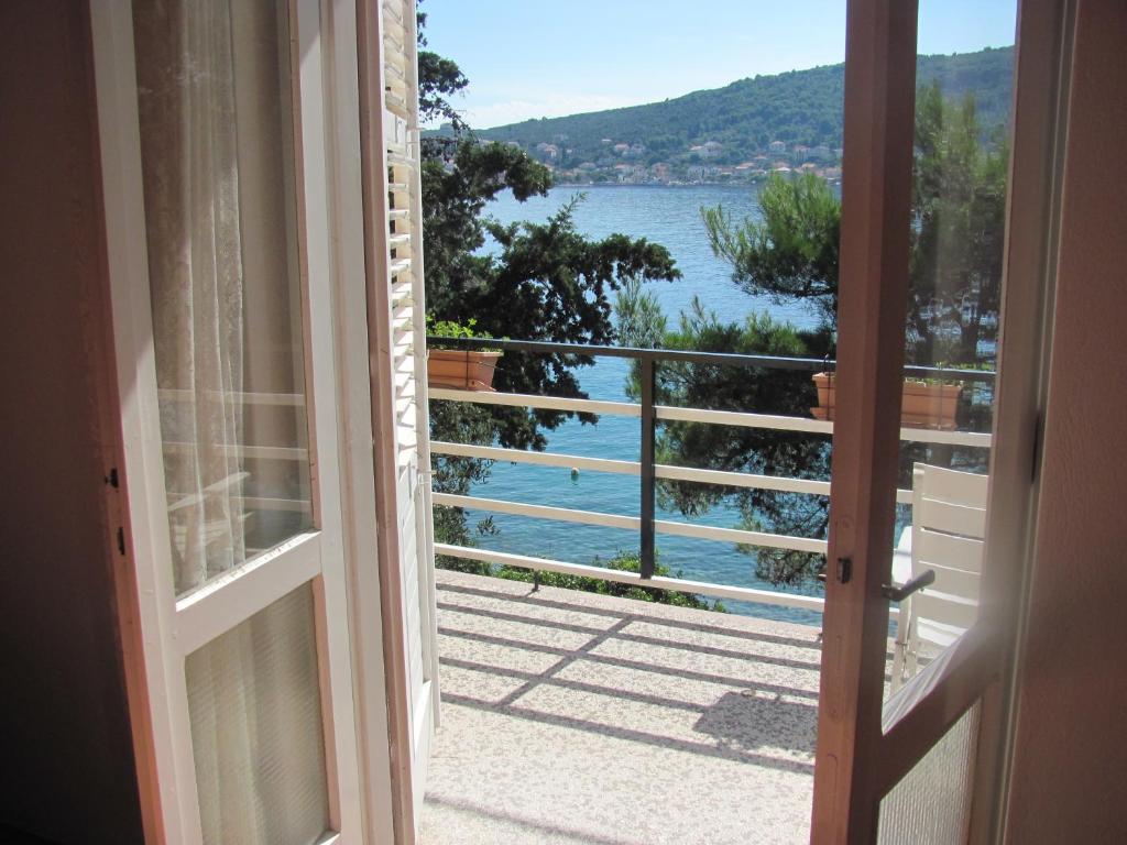 an open door to a balcony with a view of the water at Ana & Marko-Island Ošljak in Island Osljak