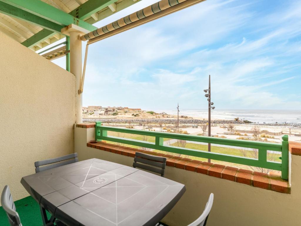 une table et des chaises sur un balcon avec vue sur la plage dans l'établissement Mimizan Plage: Appartement 6 Pers, 2 Étoiles, Ménage Inclus, Parking, Ascenseur - FR-1-50-83, à Mimizan