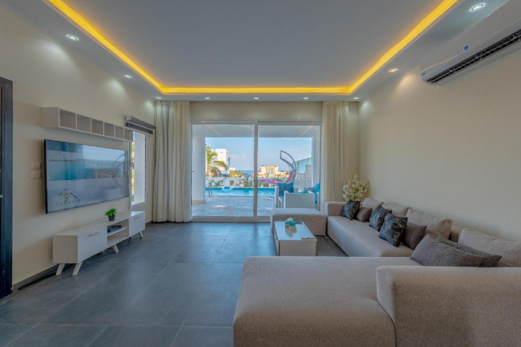 a living room with a couch and a tv at unique villa with heated pool and Spa in Hurghada