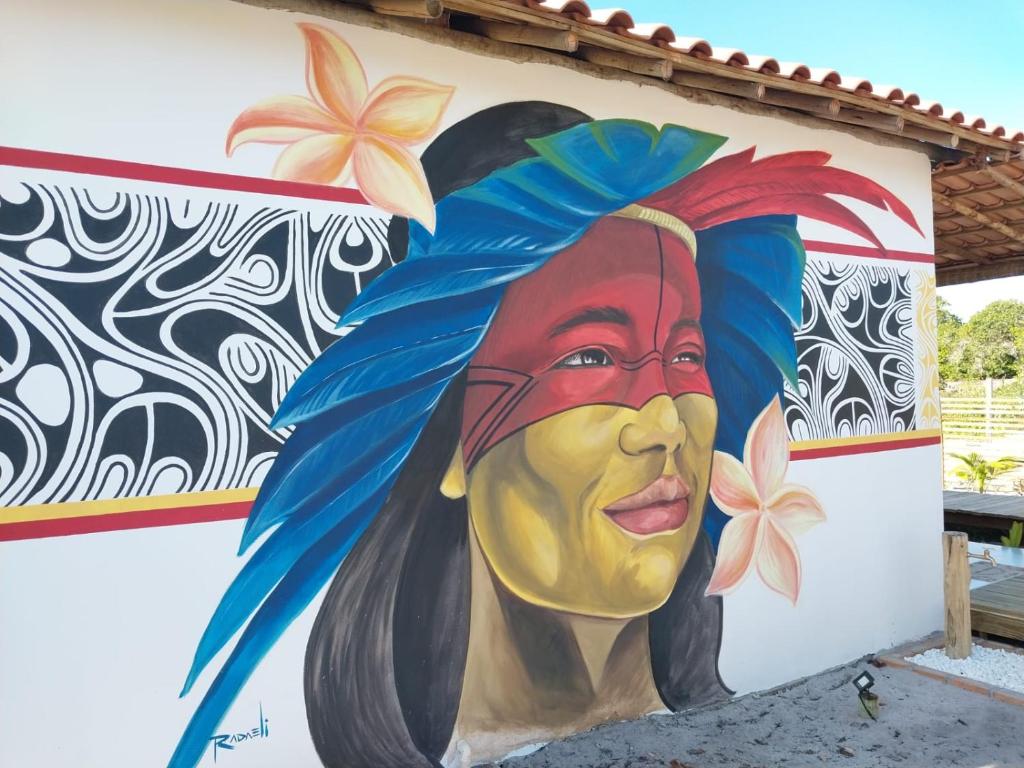 a mural of a woman painted on the side of a building at Pousada Vila Jasmim em Caraíva in Caraíva