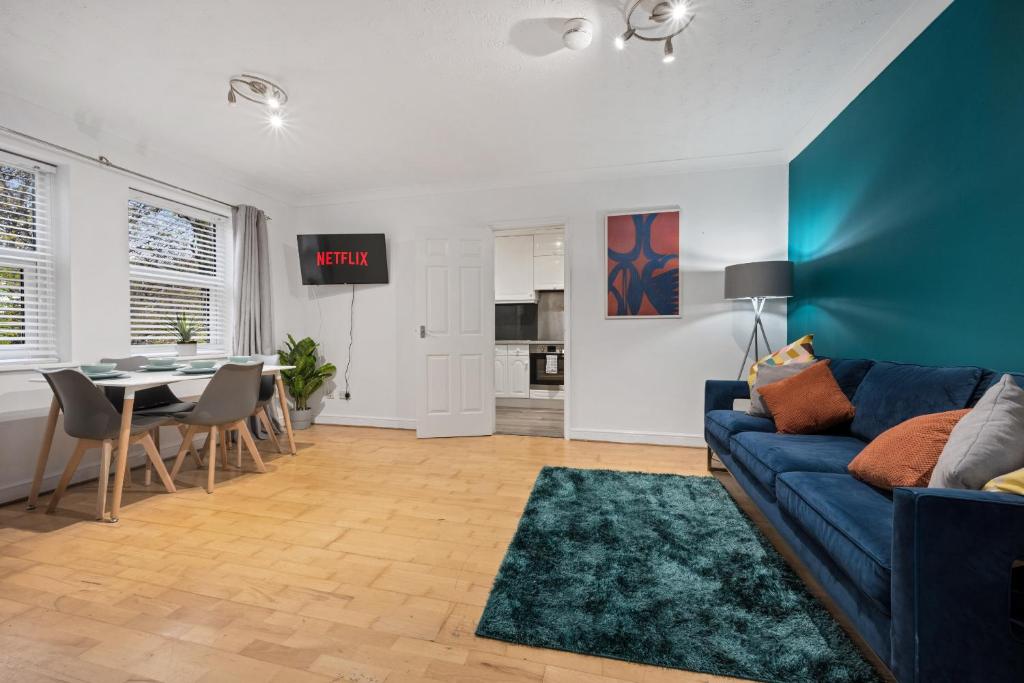 a living room with a blue couch and a table at Station Apartment High Wycombe in High Wycombe
