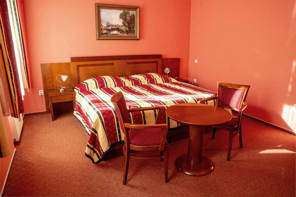 Un pat sau paturi într-o cameră la Hotel Olympia Česká Lípa