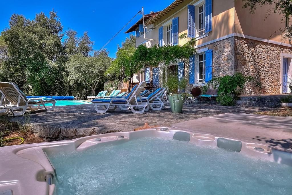 una bañera de hidromasaje en el patio trasero de una casa en Villa Provençale avec 2 maisons d'amis ,piscine ,Jacuzzi ,vue mer, en La Roquette-sur-Siagne
