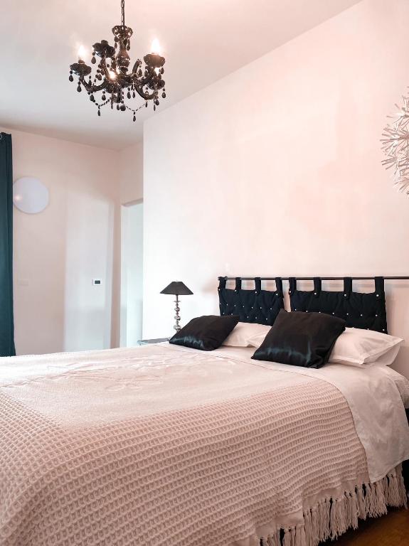 a bedroom with a large bed with a chandelier at Casa Gallinotto in Alba