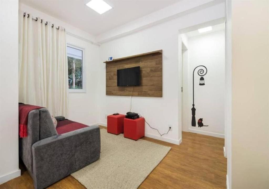 sala de estar con sofá y TV en Quality Place Apartments by BnbHost, en São Paulo