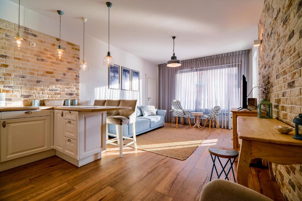 a kitchen and living room with a brick wall at CITYSTAY BraBank Apartament nad Motławą in Gdańsk