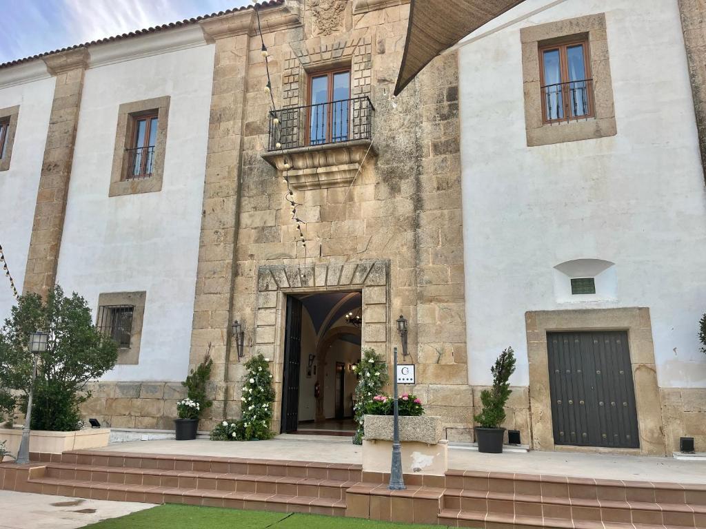 een groot stenen gebouw met een deur en ramen bij Casa Palacio El Trasquilon in Cáceres