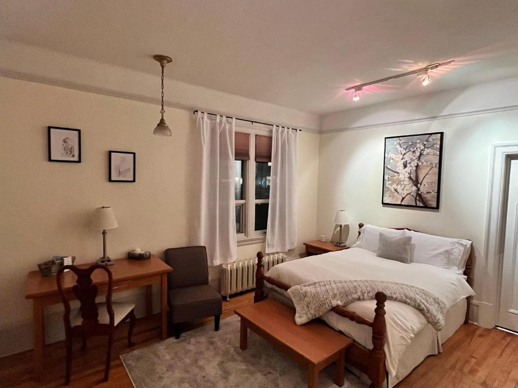 a bedroom with a bed and a desk and a chair at Stirling House in Kelowna