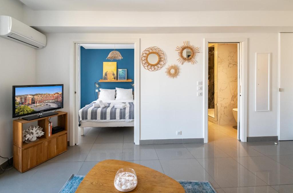 - un salon avec un lit et une télévision dans l'établissement La Maioneta Carré d'Or, à Nice